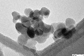 Jednotlivé nanočástice oxidu křemičitého tvořící shluky. Transmisní elektronová mikroskopie.