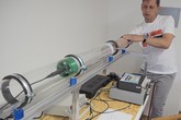 Ivo Záleský vkládá před hlukovým testem vzorek geopolymeru do polykarbonátového tubusu.