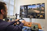 K testování únavy slouží set, jehož základem je hra Euro Truck Simulator 2. Výzkumníkovi, který má k dispozici ovládací panel, řadí i šlape na pedály, umožňuje napodobit jíjzdu v kamionu. Foto: Adam Pluhař