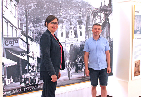 Anna Habánová a Jan Heinzl před zvětšeninou fotografie zachycující Hejnice tak před 100 lety.